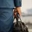 man in suit carrying black leather briefcase