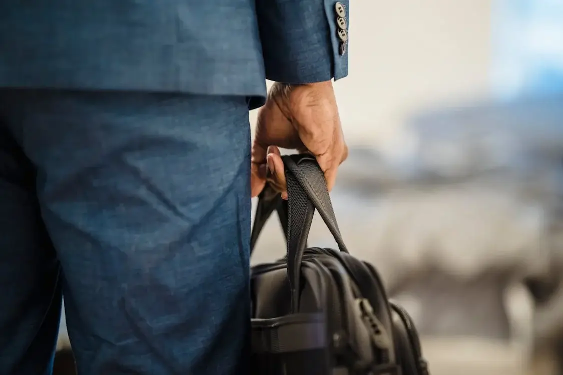 man in suit carrying black leather briefcase