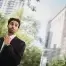 man in black suit, adjusting tie